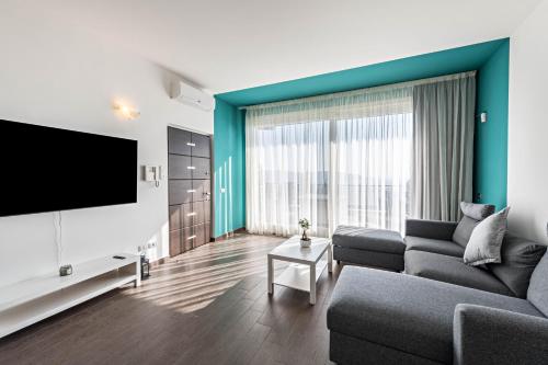 a living room with a couch and a flat screen tv at Residence Virgilio Blue in Toscolano Maderno