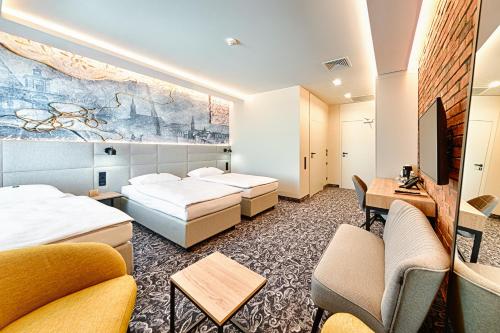 una camera d'albergo con 2 letti e una scrivania di Hotel The Loom a Łódź