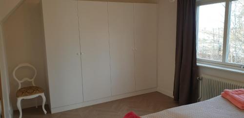 ファルシェーピングにあるSemesterhus Kymbo Jungfrugården 2のベッドと椅子と窓のある寝室