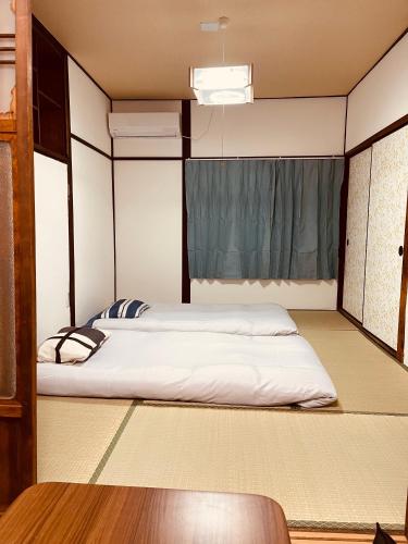 a bedroom with two beds and a window at 距离Namba Shinsaibashi麗子民宿 in Osaka