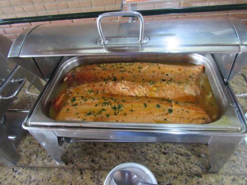 a metal pan with two fish fillets in at Hotel Cabreúva Resort in Cabreúva