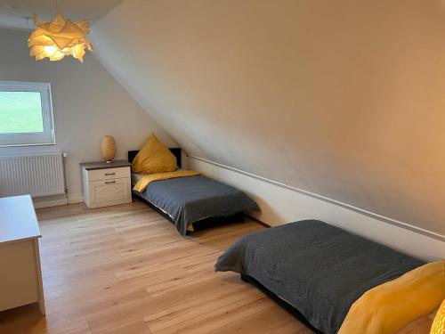 a attic room with two beds and a window at Rust-Appartements-II-Marienrode in Hildesheim