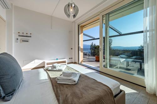 a bedroom with a bed and a large window at Residence Virgilio Green in Toscolano Maderno