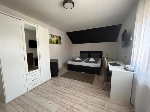 カイザースラウテルンにあるホテル ハッセルベルクのベッドとデスクが備わる小さな客室です。