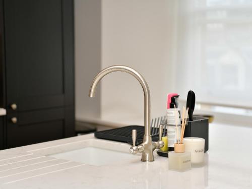 a kitchen sink with a faucet and utensils at Pass the Keys Beautiful 2 Bed Apartment with Parking in the Bay in Cardiff