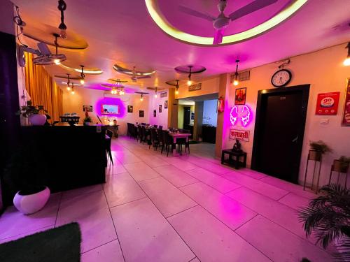 a room with purple lights and a dining room at The कस्तूरी in Maihar