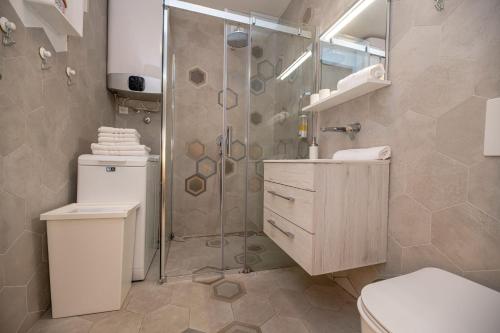 een badkamer met een douche, een toilet en een wastafel bij Apartment Sundowner in Zadar