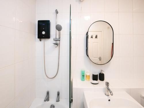 a bathroom with a shower and a sink and a mirror at Pass the Keys Cosy 2 Bed Apartment with Parking in Cardiff