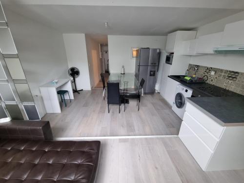 une cuisine et un salon avec un canapé et une table dans l'établissement THELNA théo, à Bray-Dunes