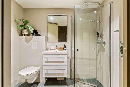 a bathroom with a shower and a toilet and a sink at Magnificent Modern Apartment — Gamle Oslo/ Bjørvika in Oslo