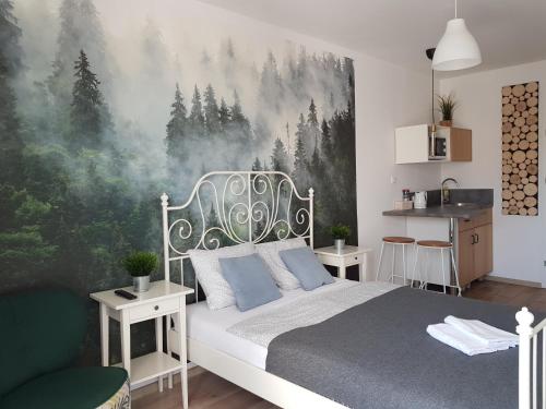 1 dormitorio con 1 cama y una pintura de árboles en NORTH, en Jastrzębia Góra