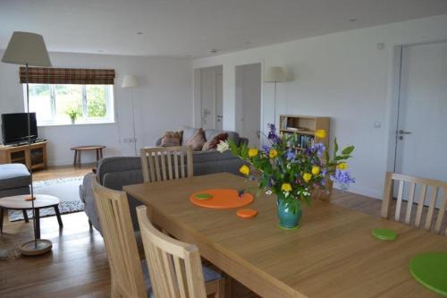 a living room with a wooden table with flowers on it at Keith View, Humbie Hub in Humbie