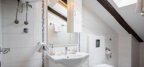 a white bathroom with a sink and a mirror at Central apartments in Pula