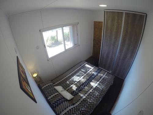Cette petite chambre dispose d'un lit et d'une fenêtre. dans l'établissement Tampu, the Container House, à Cafayate