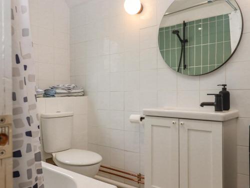 a bathroom with a toilet and a sink and a mirror at Castle Cottage in Hythe