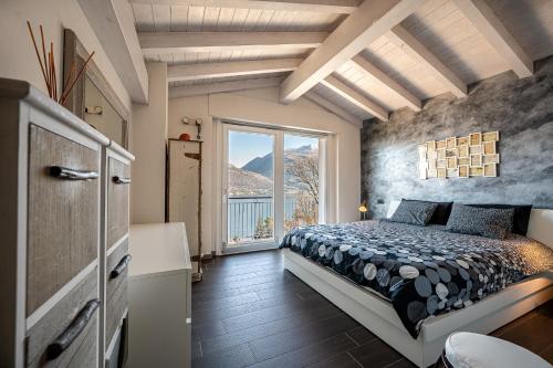 une chambre avec un lit et une grande fenêtre dans l'établissement Verde Ferienhaus mit Panorama-Seeblick, à Pianello Del Lario