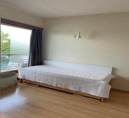 een slaapkamer met een bed en een groot raam bij Studio Laguna Beach Knokke-Heist in Knokke-Heist