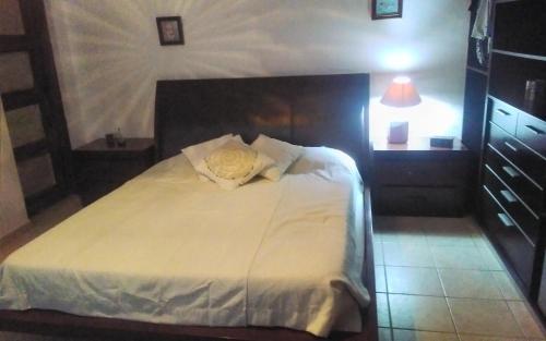 Un dormitorio con una cama blanca con una rosa amarilla. en Rincon de ensueño, en Santa Cruz de la Sierra