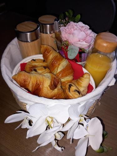 a plate of croissants and other pastries on a table at Chambre avec spa, piscine et sauna privatif in Louches