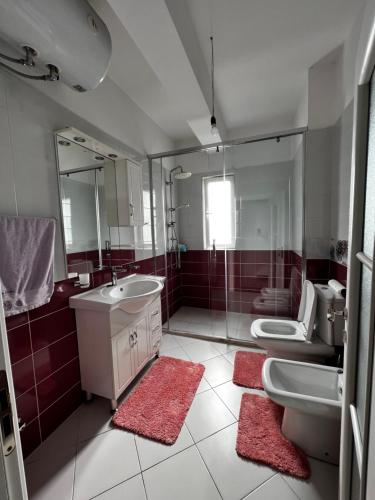 uma casa de banho com 2 lavatórios e um espelho em Noa's happy place em Tirana