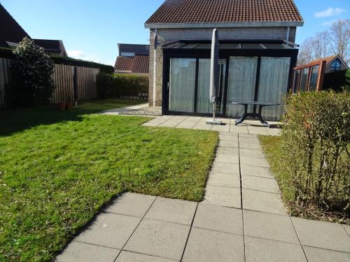 a garden with a bench in front of a building at Kustverhuur, Park Scheldeveste, Schelde 220 in Breskens