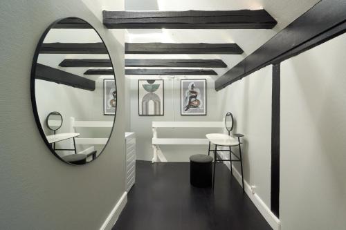 a hallway with a mirror and a table and stool at Unique 2 Bedroom Duplex w Exposed Beams in CPH City in Copenhagen