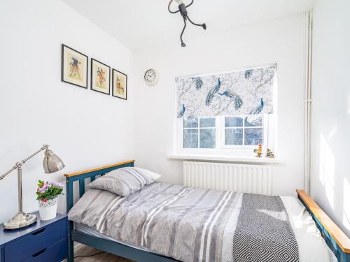 sypialnia z łóżkiem i oknem w obiekcie Pass the Keys Stylish Family Friendly 3 Bed Home in Borehamwood w mieście Borehamwood