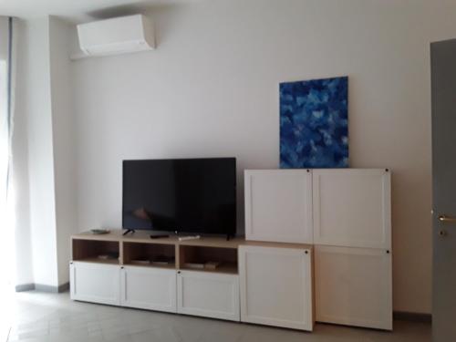 ein Wohnzimmer mit einem TV auf einem weißen Schrank in der Unterkunft Residenza Locatelli in Verona