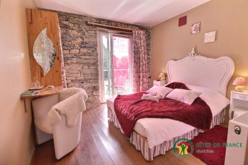 een slaapkamer met een groot bed en een stenen muur bij Chambres d'hôtes - Au Domaine des Camélias in Pluméliau