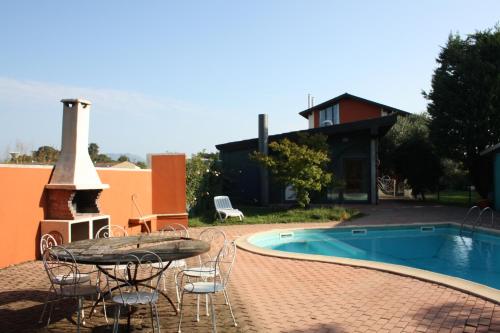 een patio met een tafel en stoelen naast een zwembad bij Agriturismo Fiorbello 