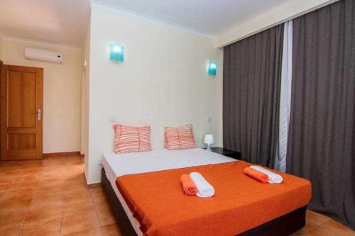 una camera da letto con un letto e due asciugamani di SunHome Casas de férias em Portimao a Portimão