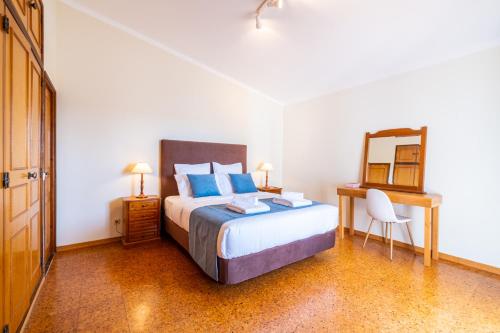 a bedroom with a bed and a desk and a mirror at Villa Estrelícia - Pool - Free wi-fi - New in Booking in Loulé
