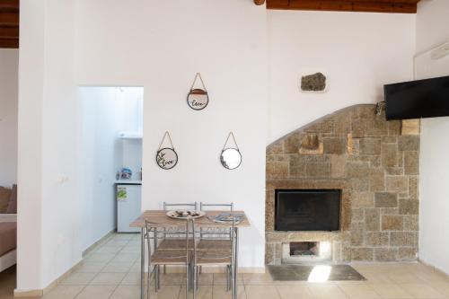 - un salon avec une table et une cheminée dans l'établissement Dimelal Mykonos Town Apartments, à Mykonos