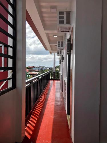 a balcony of a building with a red carpet at FN Lodge - town proper in Palompon