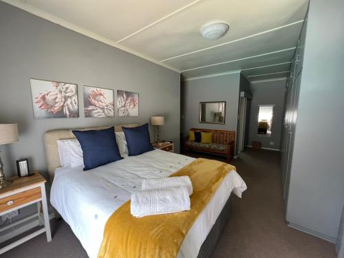 a bedroom with a large white bed with blue pillows at Ataria Place in Cradock