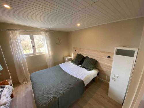 um quarto com uma cama e uma janela em La cabane familiale em Champdieu
