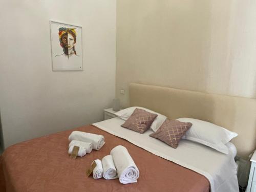 un lit avec des serviettes et une photo d'une femme dans l'établissement Sleep Inn Catania rooms - Affittacamere, à Catane