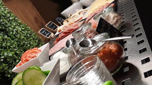 a buffet of food with spoons and vegetables at Eurostar Hotel in Castrop-Rauxel