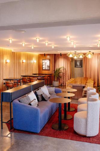 a lobby with a couch and tables and a bar at Good Hotel Guatemala City in Guatemala