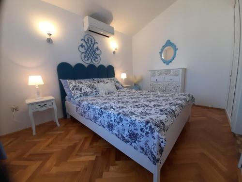 een slaapkamer met een bed met een blauwe en witte sprei bij Apartments M GREGOR ideal for relaxing holidays in Baška