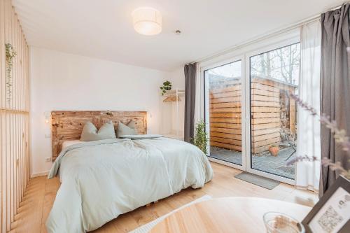 a bedroom with a bed and a large window at Apartments Kassebohmer Weg in Rostock