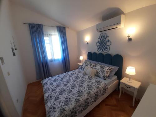 a bedroom with a bed with a blue headboard at Apartments M GREGOR ideal for relaxing holidays in Baška