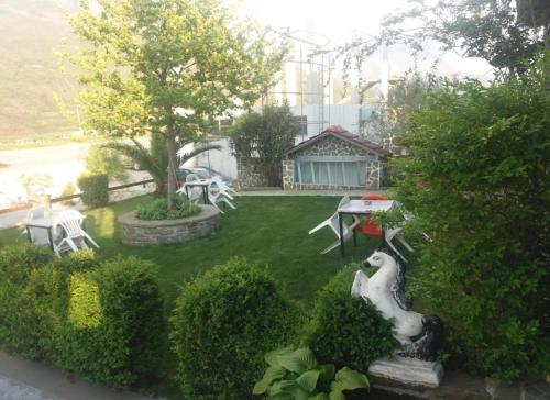 a small garden with a table and chairs in a yard at Guest-Room Zoi&Teri in Tepelenë
