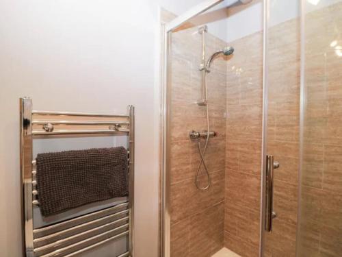 a shower with a glass door in a bathroom at The Upside Down House at The Mercers in Worcester