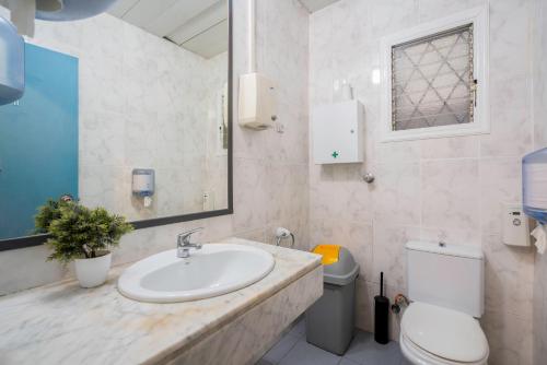 a bathroom with a sink and a toilet and a mirror at Casa Barcelo Hostel Barcelona in Barcelona