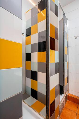 a shower stall with a colorful checkered wall at Casa Barcelo Hostel Barcelona in Barcelona