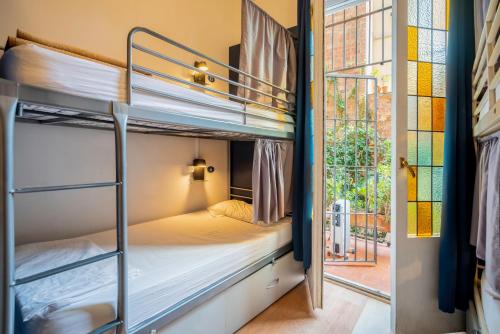 a couple of bunk beds in a room with a window at Casa Barcelo Hostel Barcelona in Barcelona
