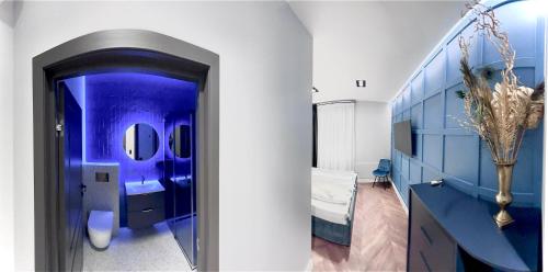 a blue bathroom with a bed and a mirror at Comfort Hostel Klaipeda in Klaipėda