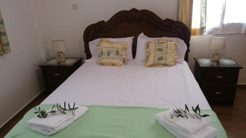 1 dormitorio con 1 cama grande y 2 mesitas de noche en Maritsa's Roses Apartments en Pomos