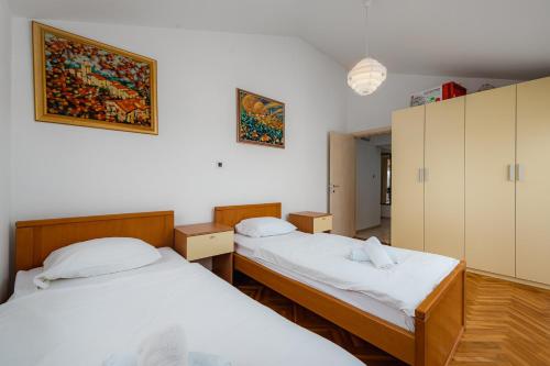 2 camas en una habitación con paredes blancas en Apartments Monterol Stella Maris, en Umag